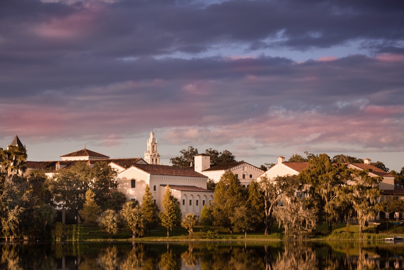 Rollins' lakeside campus at dusk with a purple sky
