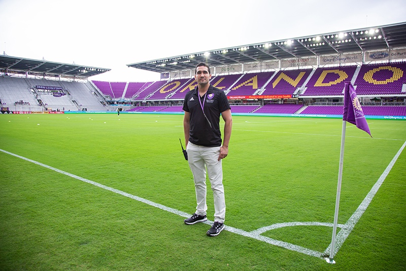 A game-day media operations interns stands in the middle of the field at Orlando City Soccer Stadium.